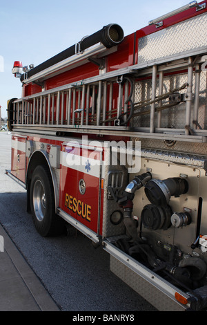 Amerikanischer roter Feuerwehrrettungswagen mit Leiter in der Stadt geparkt Seitenansicht Niemand vertikaler Tiefwinkel in den USA Hi-res Stockfoto