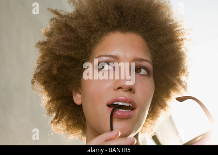 Gemischte Rassen Frau beißen auf Sonnenbrillen Stockfoto