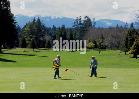 Qualicum Beach, BC, Vancouver Island, British Columbia, Kanada - ältere Senioren Golfen am Golfplatz im Frühjahr Stockfoto