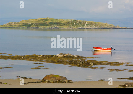 Ein Boot vor Anker am Strand bei Craighouse, Isle of Jura, auf der Suche über kleine Inseln Bucht auf Eilean Bhride. Stockfoto