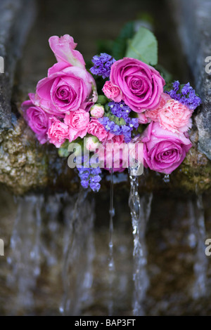 Rosen an einem Brunnen während der Bisley gut kleiden custom bei Bisley, Gloucestershire platziert. Stockfoto