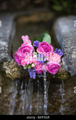 Rosen an einem Brunnen während der Bisley gut kleiden custom bei Bisley, Gloucestershire platziert. Stockfoto