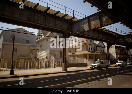 Einfamilienhäuser an der Roosevelt Avenue befindet sich unter der erhöhten Zahl 7 Flushing-u-Bahnlinie in Corona, Queens, New York Stockfoto