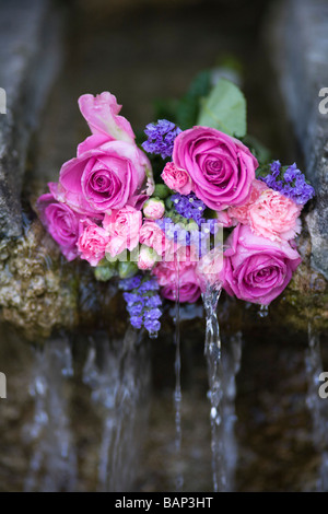 Rosen an einem Brunnen während der Bisley gut kleiden custom bei Bisley, Gloucestershire platziert. Stockfoto