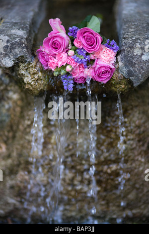 Rosen an einem Brunnen während der Bisley gut kleiden custom bei Bisley, Gloucestershire platziert. Stockfoto