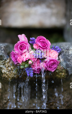 Rosen an einem Brunnen während der Bisley gut kleiden custom bei Bisley, Gloucestershire platziert. Stockfoto