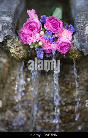 Rosen an einem Brunnen während der Bisley gut kleiden custom bei Bisley, Gloucestershire platziert. Stockfoto