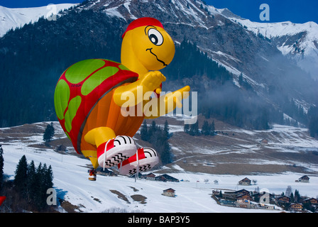 Schildkröte Form geformt Ballon mit blauem Himmel und Schnee bedeckt Alpen: 2009 Chateau d ' Oex internationalen Hot Air Balloon Festival. Stockfoto