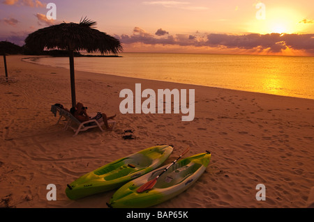 Paar unter Sonnenschirm am Strand Cat Island, Bahamas. Stockfoto