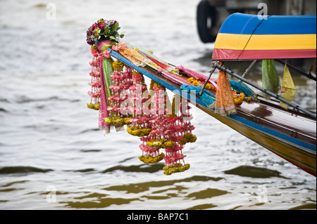 Bunte Blumengirlanden am Bug ein Longtail-Boot. Chao-Phraya-Fluss, Bangkok, Thailand. Stockfoto