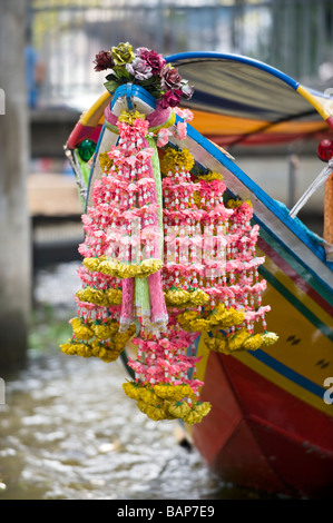 Bunte Blumengirlanden am Bug ein Longtail-Boot. Chao-Phraya-Fluss, Bangkok, Thailand. Stockfoto