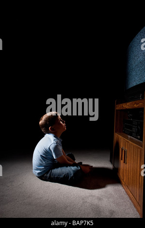 Sechs Jahre alter Junge statisch im Fernsehen im Dunkeln beobachten Stockfoto