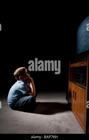 Sechs Jahre alter Junge statisch im Fernsehen im Dunkeln beobachten Stockfoto