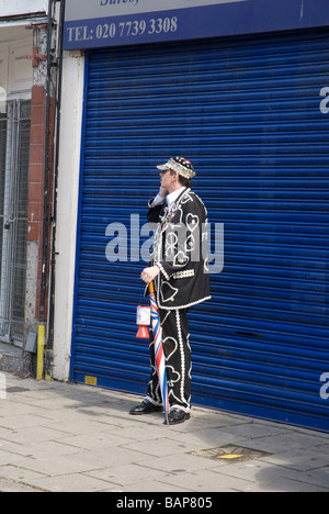 Hoxton Street Party 1948 Olympics feiern Tag die Olympische Flagge wurde für die Spiele 2012 in London an. Pearly King auf dem Handy Stockfoto