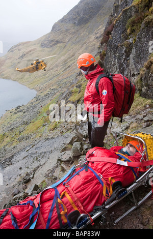 Ein Spaziergänger mit einer zusammengesetzten Bein Fraktur wird von Langdale Ambleside Bergrettung in leicht Gully auf Pavey Arche behandelt. Stockfoto