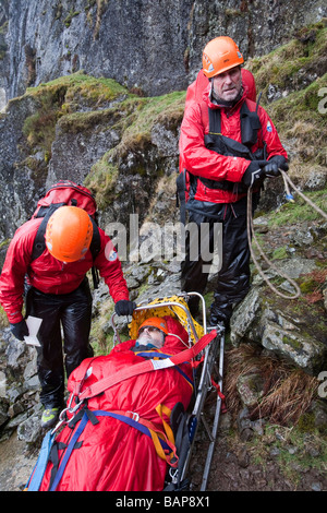 Ein Spaziergänger mit einer zusammengesetzten Bein Fraktur wird von Langdale Ambleside Bergrettung in leicht Gully auf Pavey Arche behandelt. Stockfoto