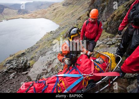 Ein Spaziergänger mit einer zusammengesetzten Bein Fraktur wird von Langdale Ambleside Bergrettung in leicht Gully auf Pavey Arche behandelt. Stockfoto