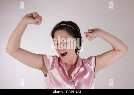 Mädchen oder Frau trägt Pyjama dehnen und Gähnen vor dem Schlafengehen oder morgens nach dem Aufwachen Stockfoto