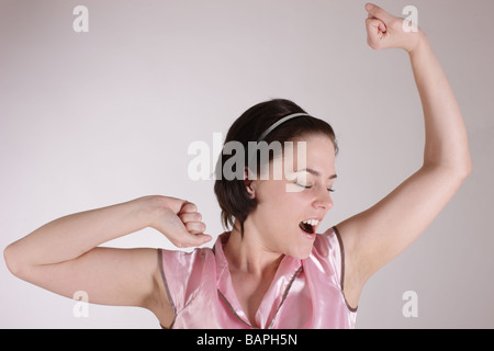 Mädchen oder eine Frau im Ping Pyjama streckte die Arme nach dem Aufwachen Stockfoto