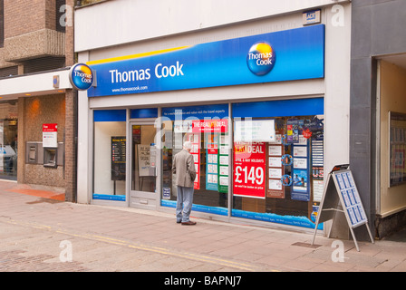 Ein älterer Mann auf der Suche im Fenster der Thomas Cook Reisebüros Shop Store in Norwich, Norfolk, Großbritannien Stockfoto