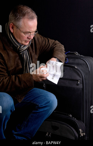 Mann, der einen Räumungsbefehl hält; Mann ausziehen Stockfoto