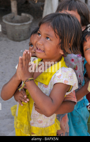 Moken Kinder Aufmachungen Handflächen zusammen Wai und Warteschlange von Tourist, Koh Phayam, Ranong, Südthailand zu süß. Stockfoto