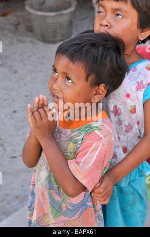 Moken Kinder Aufmachungen Handflächen zusammen Wai und Warteschlange zu süß aus Touristen, Koh Phayam, Ranong, Süd-thailand Stockfoto