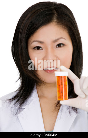 Asiatischen Arzt hält eine Flasche Pillen Stockfoto