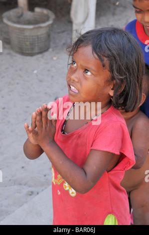 Moken Kinder Aufmachungen Handflächen zusammen Wai und Warteschlange von Tourist, Koh Phayam, Ranong, Südthailand zu süß. Stockfoto