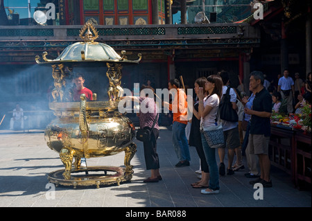 Buddhistischen und taoistischen Anbeter Räucherstäbchen als Ritual von Mengjia Lungshan Tempel. Taipei, Taiwan. Stockfoto