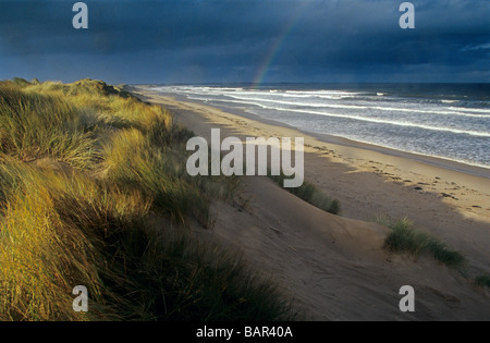 Stürmischen Himmel und ein Regenbogen über druridge Bay an der Küste von Northumberland, England Stockfoto