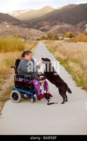 Frau benutzt ihr Elektro-Rollstuhl, den Wanderweg in den kleinen Berg Stadt Salida Colorado USA zu navigieren Stockfoto