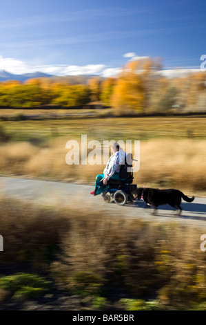 Frau benutzt ihr Elektro-Rollstuhl, den Wanderweg in den kleinen Berg Stadt Salida Colorado USA zu navigieren Stockfoto
