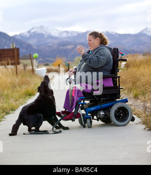 Frau benutzt ihr Elektro-Rollstuhl, den Wanderweg in den kleinen Berg Stadt Salida Colorado USA zu navigieren Stockfoto