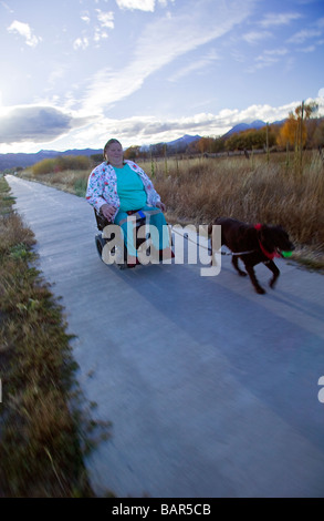 Frau benutzt ihr Elektro-Rollstuhl, den Wanderweg in den kleinen Berg Stadt Salida Colorado USA zu navigieren Stockfoto
