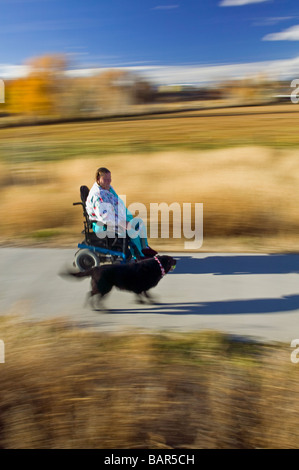 Frau benutzt ihr Elektro-Rollstuhl, den Wanderweg in den kleinen Berg Stadt Salida Colorado USA zu navigieren Stockfoto