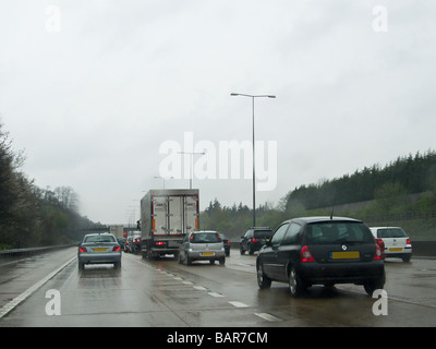 Warteschlangen Verkehr auf der Autobahn M25 in nassen Wetter, England Stockfoto