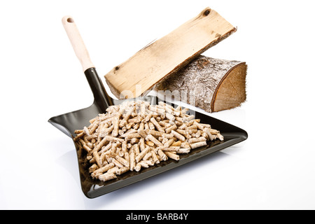 Holzpellets auf Kehrschaufel und Protokolle, close-up Stockfoto