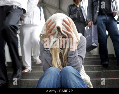 Junge Frau sitzt auf der Treppe Stockfoto