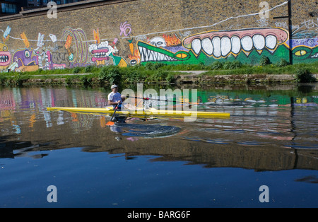 Kanufahrer auf Fluss Lee London neben Wand mit Graffiti mit Krokodilen. Stockfoto