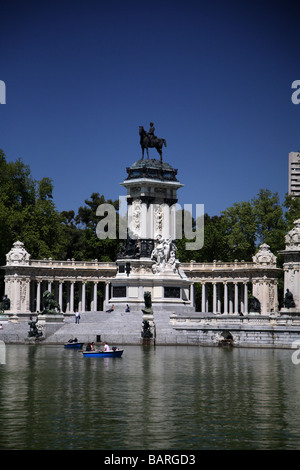 Denkmal mit Blick auf den See mit Booten im Parque del Retiro, Madrid, Spanien. Stockfoto