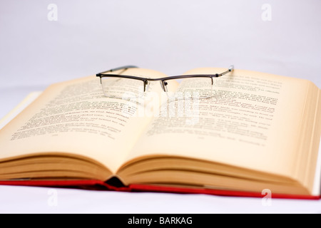 Brille auf ein offenes Buch Stockfoto