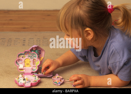 kleine Mädchen spielen mit Polly Pocket-Miniatur-Spielzeug Stockfoto