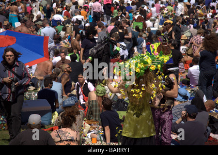 Massenszene bei Dolores Park Mann im grünen Kleid mit großen gelben Hut im Vordergrund Stockfoto