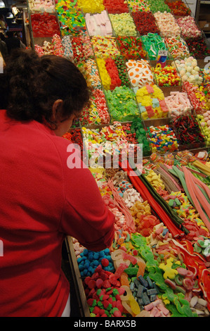 Rückseite der Verkäuferin am Süßigkeiten-Stand in der Boqueria-Markt in Barcelona, Spanien Stockfoto