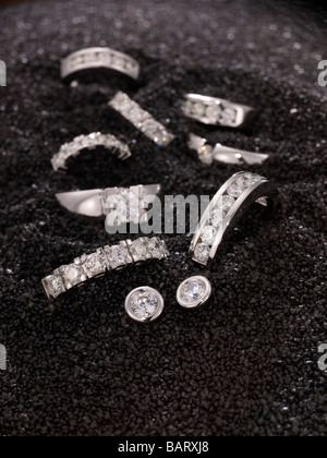 Diamant-Ringe und Ohrringe auf schwarzem sand Stockfoto