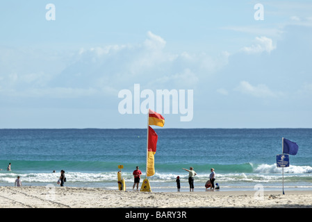 Lebensrettende Flagge weht eine Brise am Strand Stockfoto