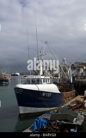 Gewitterwolken wälzen sich der Fischereiflotte vertäut im Hafen von Weymouth in Dorset, England. Stockfoto