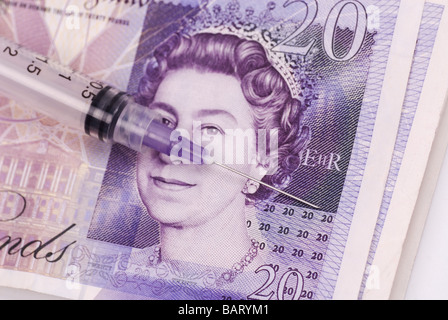 Medizinische Injektion über einen Haufen britisches Geld Stockfoto