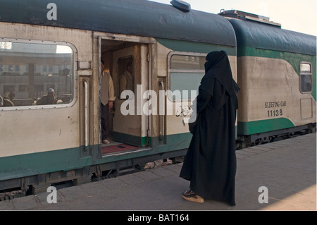 Eine ägyptische Frau in traditionellem schwarzem Gewand der Abaya in einem Schlafzug von Kairo nach Luxor in Ägypten Stockfoto